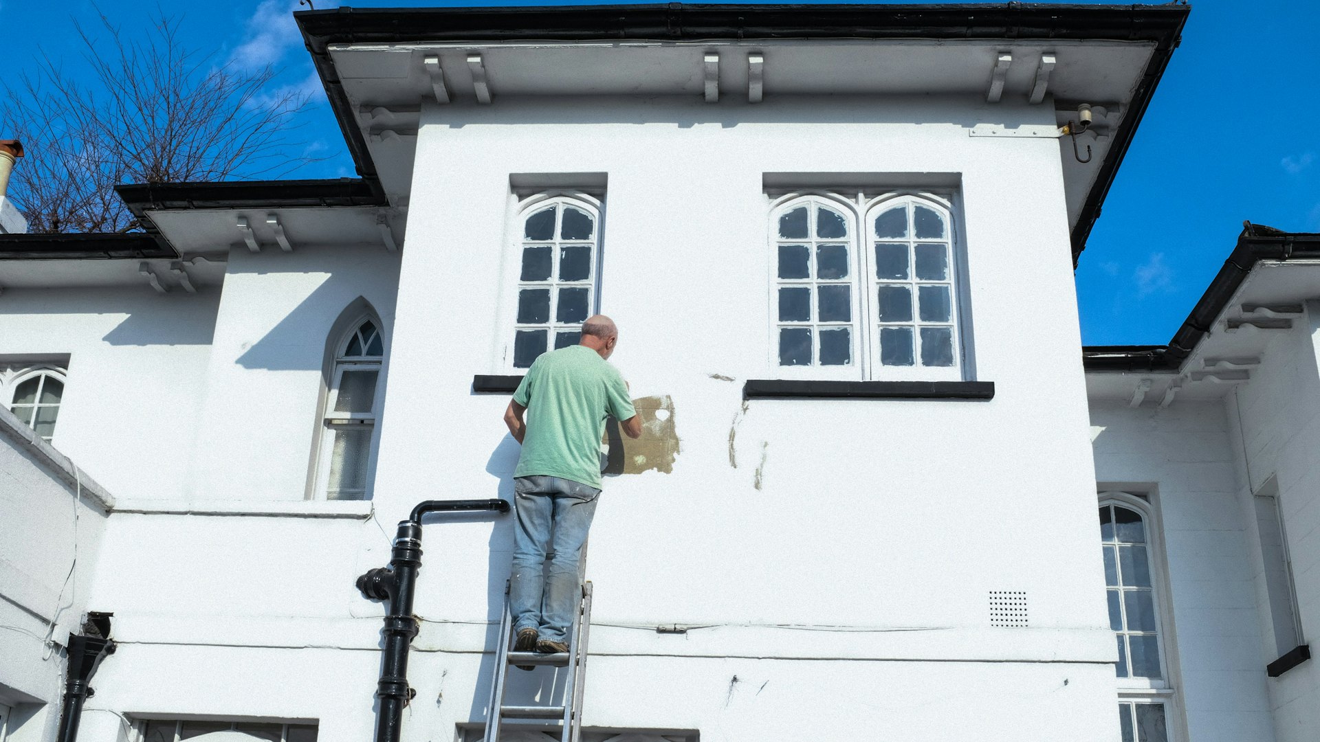 Schilder aan het werk aan een witte gevel